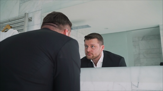 Businessman washes his hands. Before work. Busy prosperous businessman washing his hands in the morning before going to work