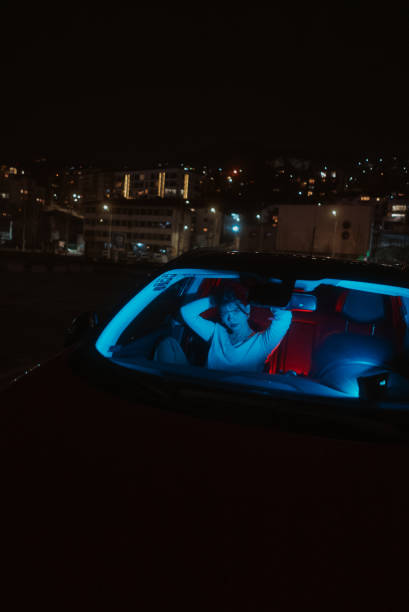 Portrait of Young Woman at Night in a Car With Colored Lights stock photo