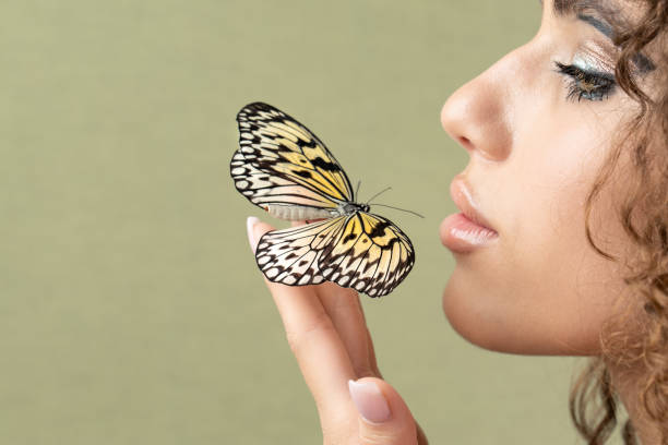 istock butterfly on the palm, green background, copytext 1390543661