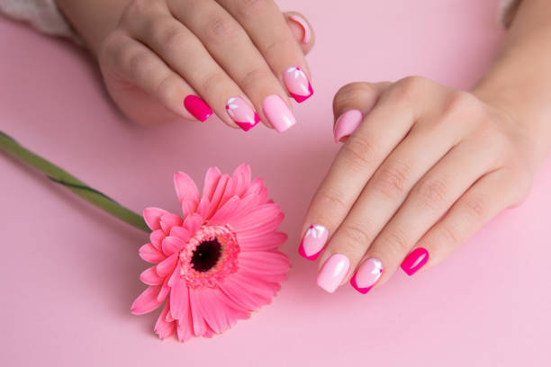 istock Female hands with pink manicure, flowers design 1390546832