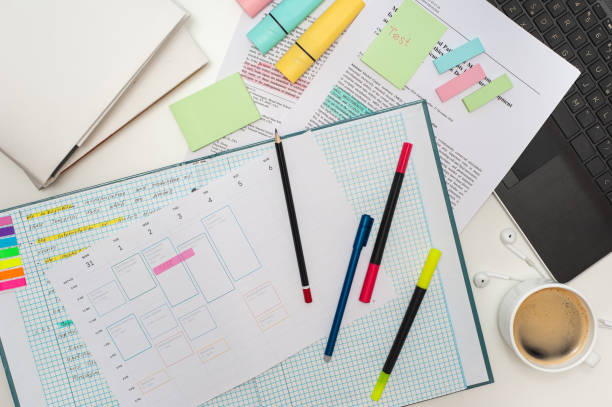 istock Student's workspace. Top view of the table filled with notes, notebooks, stickers and markers and a cup of coffee. Study schedule on the table. 1390551671