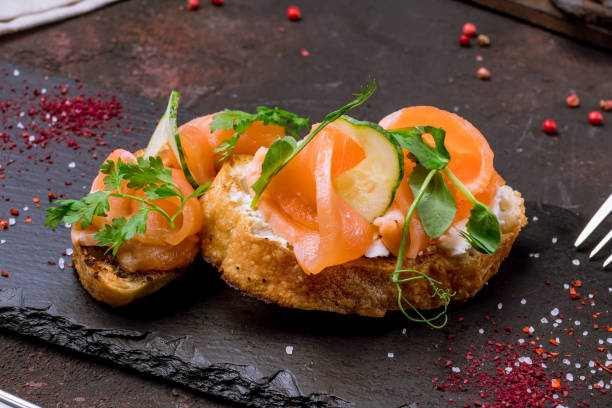 istock Bruschetta with salmon and cheese on black plate macro close up 1390552882
