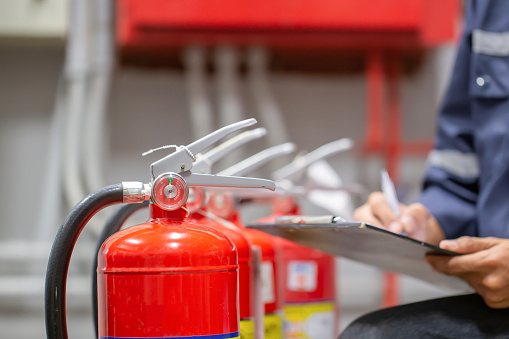 Engineer are checking and inspection a fire extinguishers tank in the fire control room for safety training and fire prevention.