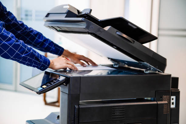istock Businessmen press button on the panel for using photocopier or printer for printout and scanning document paper at office. 1390554084
