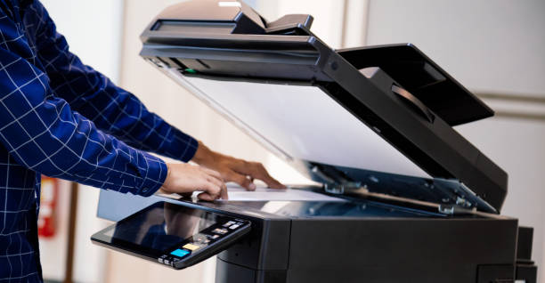 istock Businessmen press button on the panel for using photocopier or printer for printout and scanning document paper at office. 1390554088