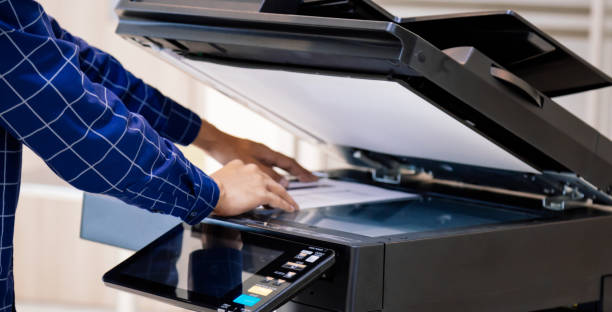 istock Businessmen press button on the panel for using photocopier or printer for printout and scanning document paper at office. 1390554091