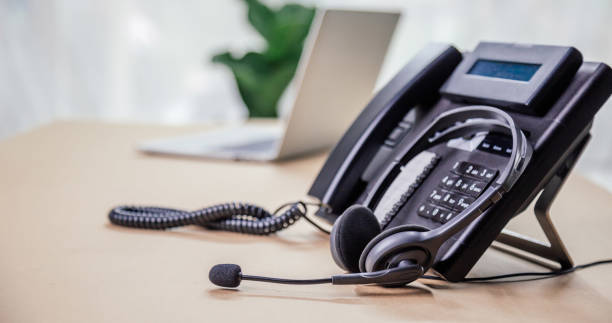 istock Communication support, call center and customer service help desk. telephone devices with VOIP headset in office.Customer service support (call center) concept. 1390554101
