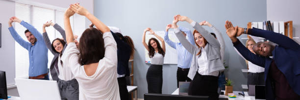 istock Group Of Smiling Multi-ethnic Businesspeople Doing Exercise 1390560364