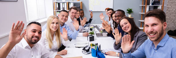 Happy Group Of Businesspeople Waving Hands In Office Happy Business Group Of Diverse People Waving Hands During A Meeting Conference In The Office greeting stock pictures, royalty-free photos & images