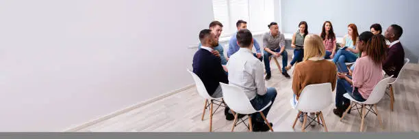 Young Multiracial Millennial Friends Sitting In Circle Having Group Discussion
