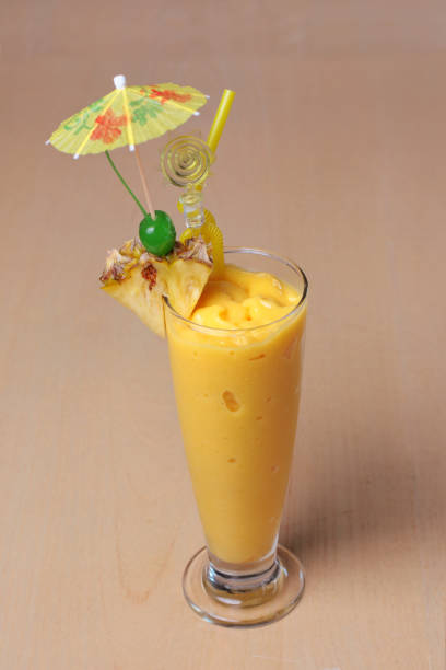 бокал ананасового кокосового смузи или молочного коктейля со свежими фруктами, классически оформленными на деревянном столе на десерт - pineapple milkshake стоковые фото и изображения