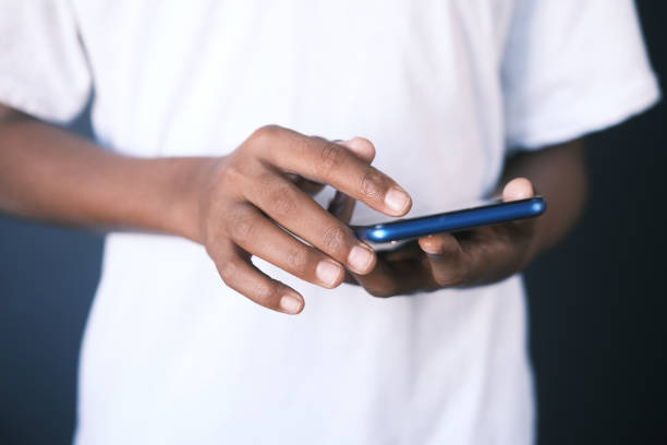 istock Close up of young man hand using smart phone. 1390568385