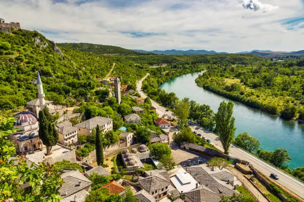 Photo of Alija Mosque and the emerald waters of Neretva River, Pocitelj, Bosnia