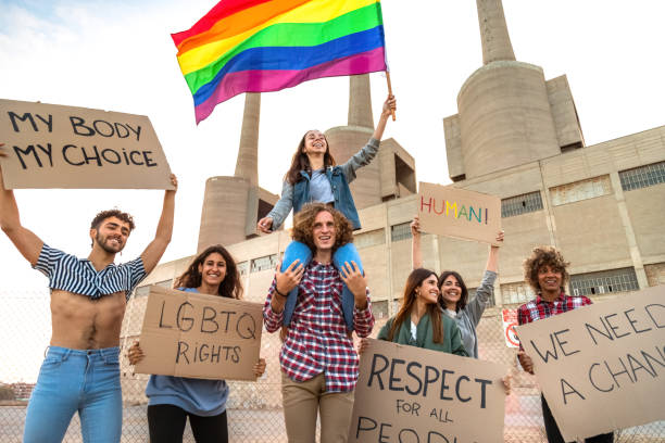 istock Multiracial protesters demonstrate for LGTB rights holdings placards and waving rainbow flag 1390578694