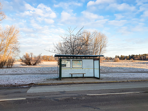 Sweden, Stockholm, December 22, 2021: Bus stop shelter with frosty glas  on Djurgården Island in a sunny winter day