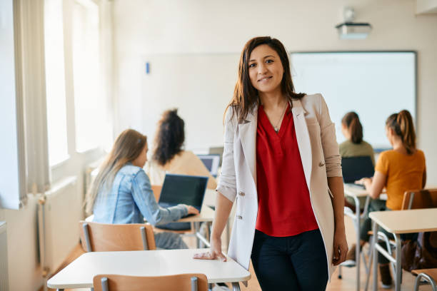 istock Happy computer science teacher in the classroom looking at camera. 1390581195