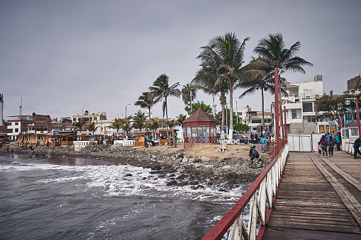 Huanchaco - July 13, 2018 : People at pier with view of town at the background