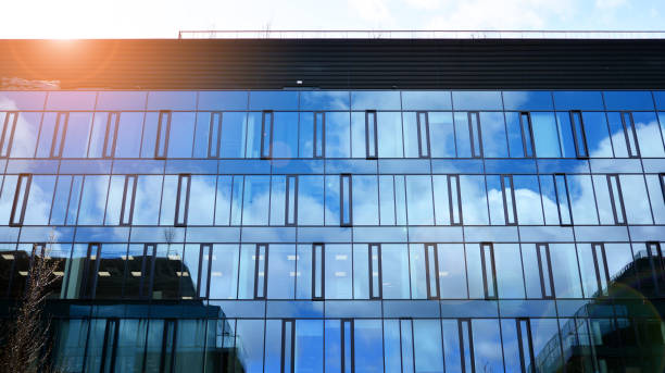 istock Modern office building with glass facade on a clear sky background. 1390584346