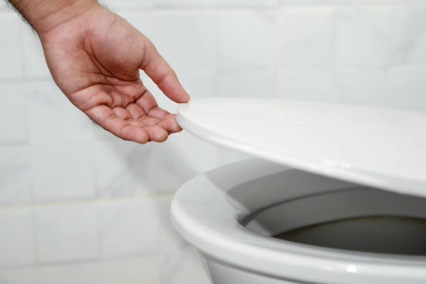 istock man's hand opening the toilet lid 1390585498