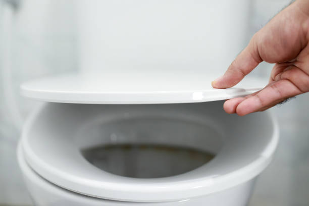 istock man's hand opening the toilet lid 1390585577