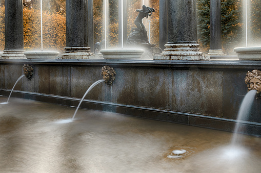 PETERHOF, ST. PETERSBURG, RUSSIA - OCTOBER 02, 2021: Lion fountain cascade with three mascarons and a statue in Indian summer. UNESCO World Heritage Site. Architecture of the 19th century.