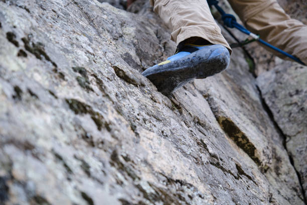 istock Crop man in boots climbing rocky mountain 1390590502