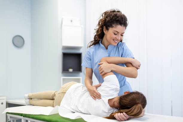 Physiotherapist treatment patient. Holding patient's hand, shoulder joint treatment. Physical Doctor consulting with patient About Shoulder muscule pain problems Physical therapy diagnosing concept Physiotherapist treatment patient. Holding patient's hand, shoulder joint treatment. Physical Doctor consulting with patient About Shoulder muscule pain problems Physical therapy diagnosing concept scapula stock pictures, royalty-free photos & images