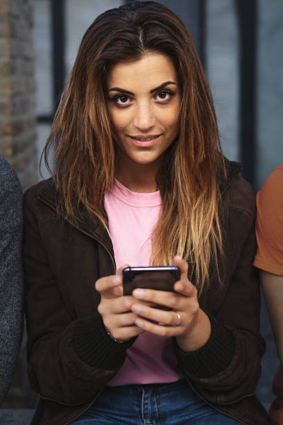 istock Young woman using a smartphone outdoors 1390594478