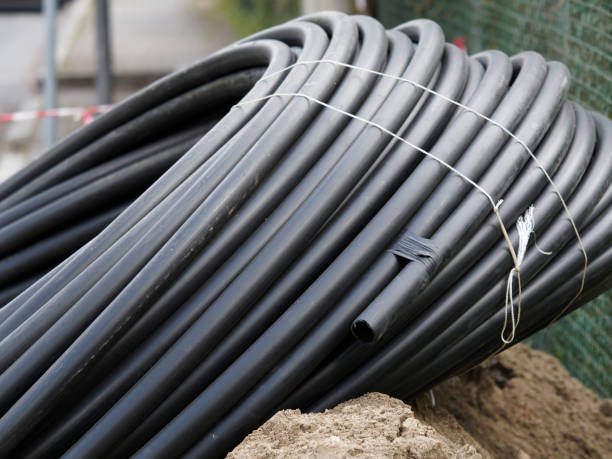 coiled black plastic pipes stored outdoors - industrislang bildbanksfoton och bilder