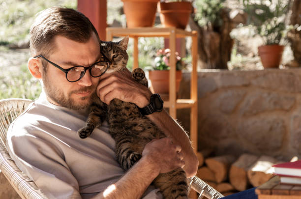 istock Handsome man in glasses hugging his cute cat. 1390598450