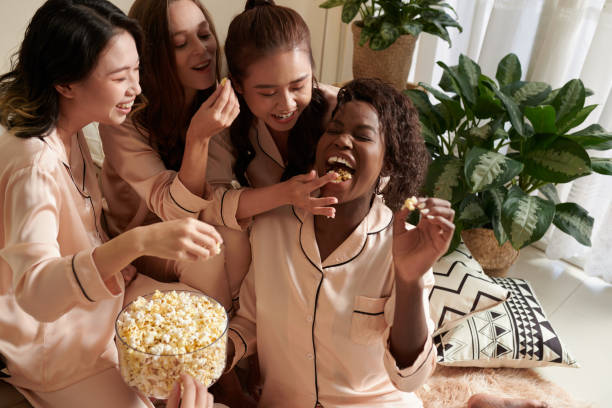 istock Joyful Friends Playing With Popcorn 1390598745