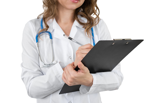 A doctor in a dressing gown writes on a tablet. Isolated on white background.