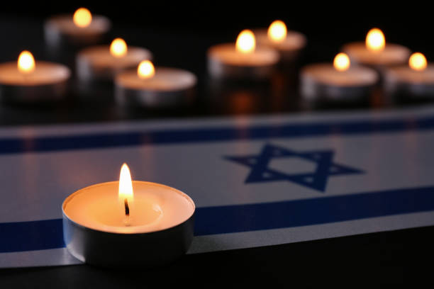 黒いテーブルの上でろうそくとイスラエルの旗を燃やす。ホロコースト追悼の日 - confined space ストックフォトと画像