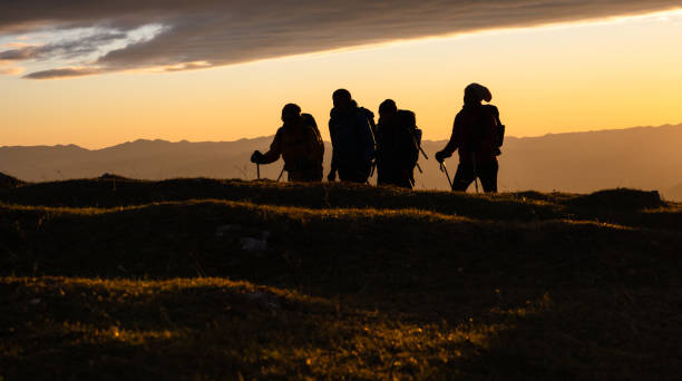 istock Silhouettes Of Hikers At Sunset 1390606062
