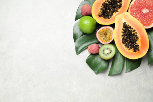 istock Fresh ripe papaya and other fruits on light grey table, flat lay. space for text 1390606318
