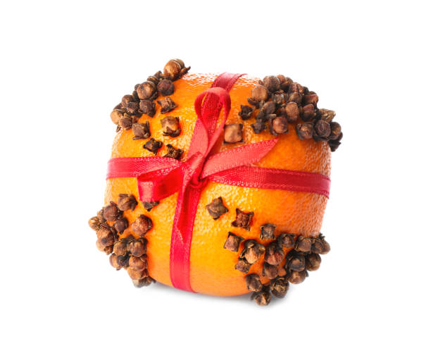 Pomander ball with red ribbon made of fresh tangerine and cloves isolated on white Pomander ball with red ribbon made of fresh tangerine and cloves isolated on white scent container stock pictures, royalty-free photos & images