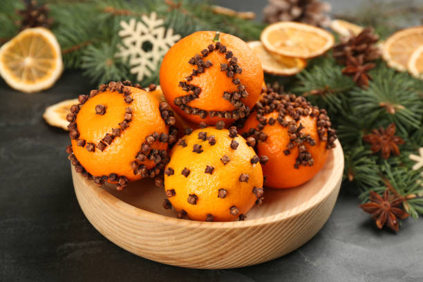 Pomander balls made of fresh tangerines with cloves  on dark table, closeup. Christmas atmosphere Pomander balls made of fresh tangerines with cloves  on dark table, closeup. Christmas atmosphere scent container stock pictures, royalty-free photos & images