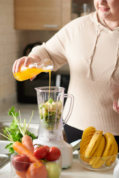 istock Woman Pouring Juice in Blender 1390609541