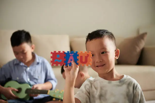 Photo of Vietnamese Boy Playing with Alphabet Puzzle