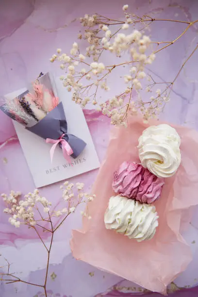 Delicate pink and white marshmallow with decoration of gypsophila and dryflowers bouquet. Cozy winter weekends. Girly background. Homemade sweets. High quality photo