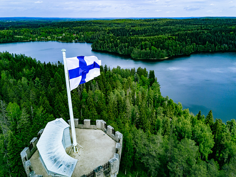 Aerial view of observation tower with Finnish flag among blue lakes and green forests in summer Finland. Aulanko Observation Tower, Hameenlinna, Finland
