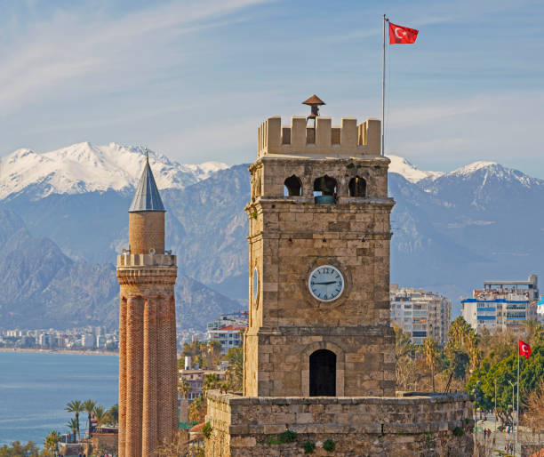 old town antalya with the clock tower and  yivli minaret (fluted minaret) mediterranean sea and taurus mountains on background - província de antália imagens e fotografias de stock