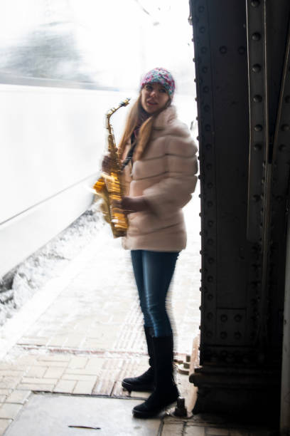 ukraińska piękna dziewczyna gra na saksofonie na dworcu kolejowym we lwowie - playing an instrument vertical blurred motion outdoors zdjęcia i obrazy z banku zdjęć