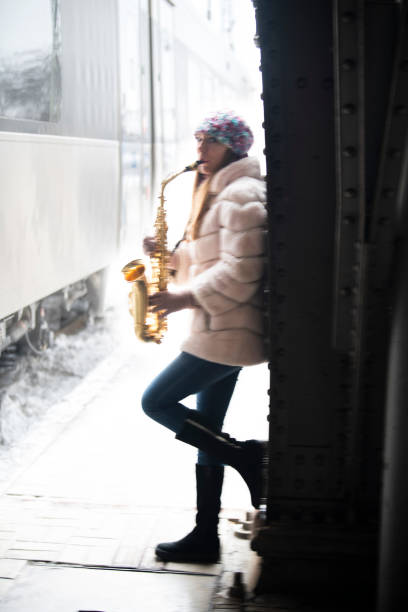 ukraińska piękna dziewczyna gra na saksofonie na dworcu kolejowym we lwowie - playing an instrument vertical blurred motion outdoors zdjęcia i obrazy z banku zdjęć
