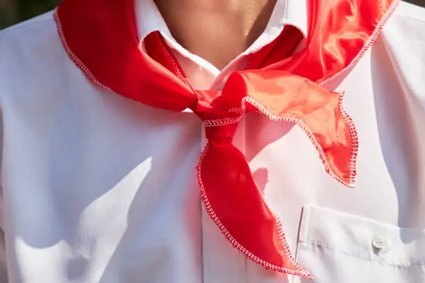 Red pioneer tie on the neck of the teenager as a symbol of socialism
