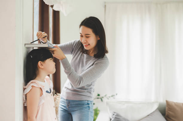 matka pomiaru wysokości dziewczynki w pobliżu ściany - growth child human height short zdjęcia i obrazy z banku zdjęć