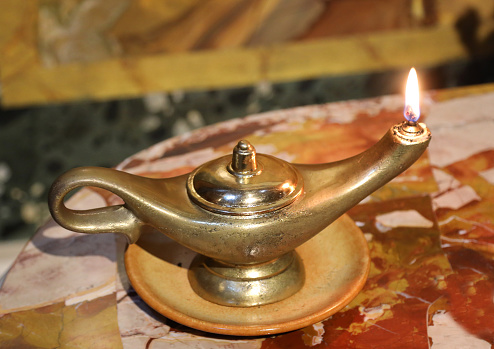 Ancient vintage golden oil lamp with flame that burn