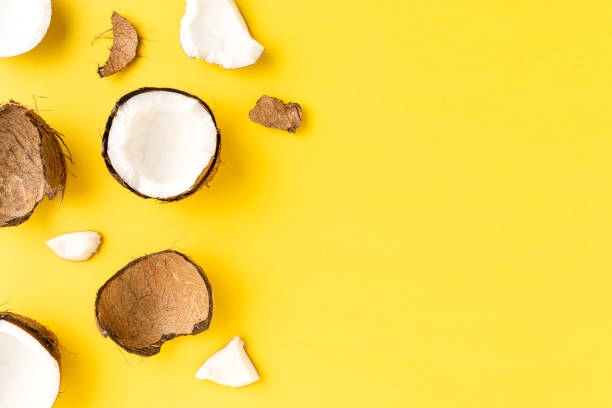 istock Coconut pieces on yellow background with copyspace. Flat lat. Top view 1390634380
