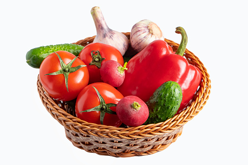 Assorted fresh vegetables in a basket on a white background. Eco food concept. Place for text.