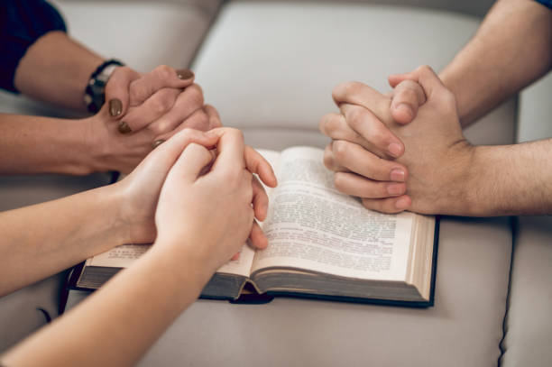 istock Close up picture of hands while praying 1390636704
